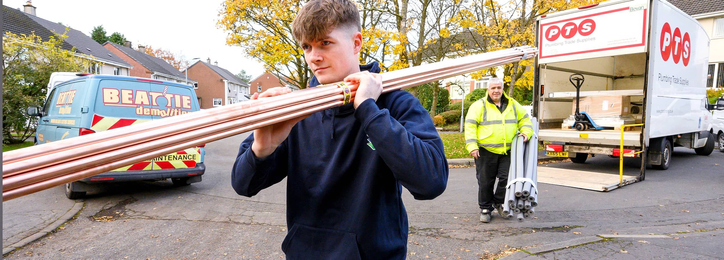 Apprentice carrying pipes
