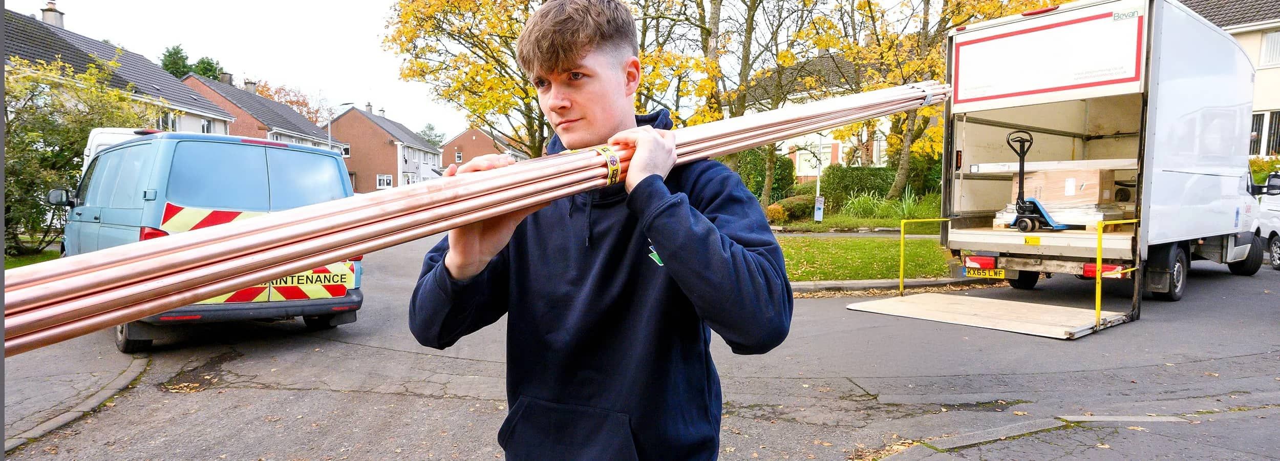 Apprentice carrying pipes